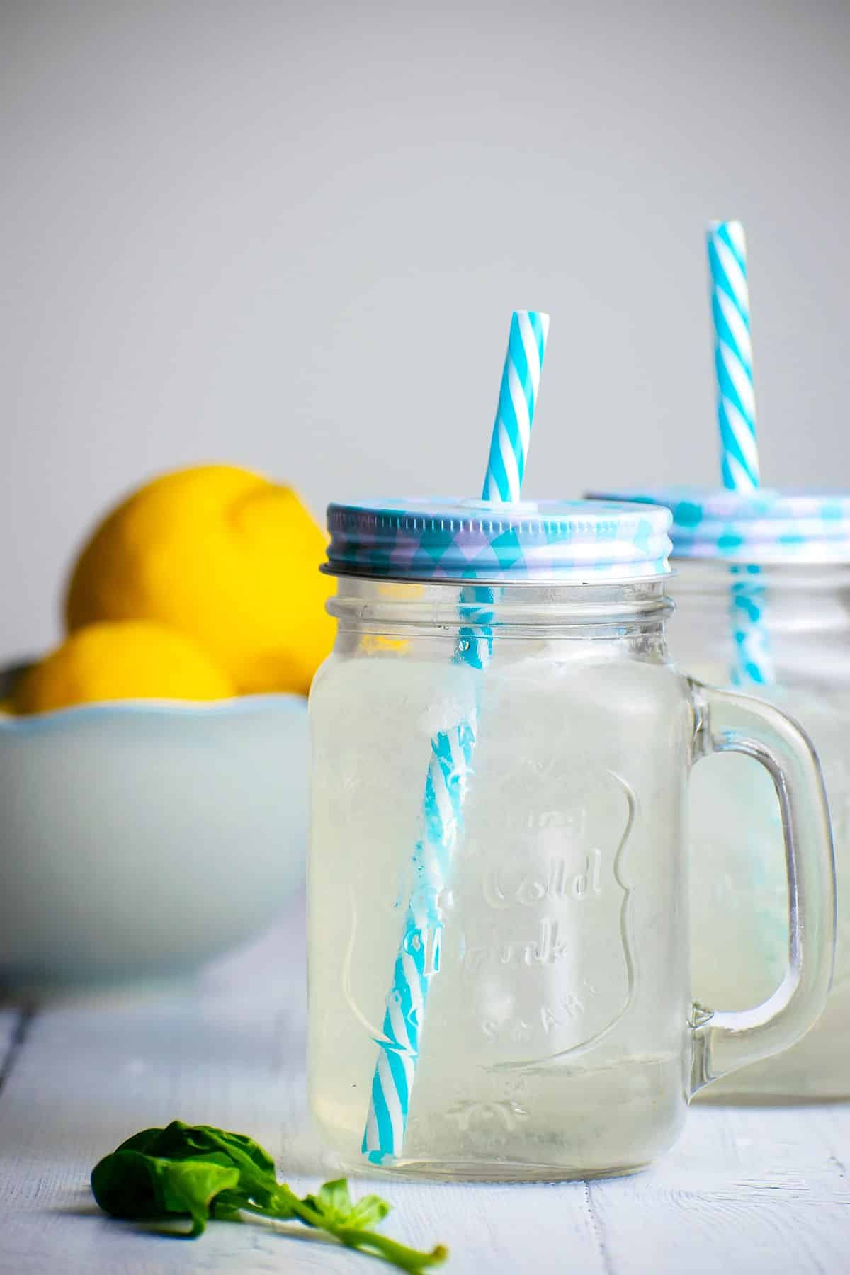 Lemonade in jars with blue lids and straws.