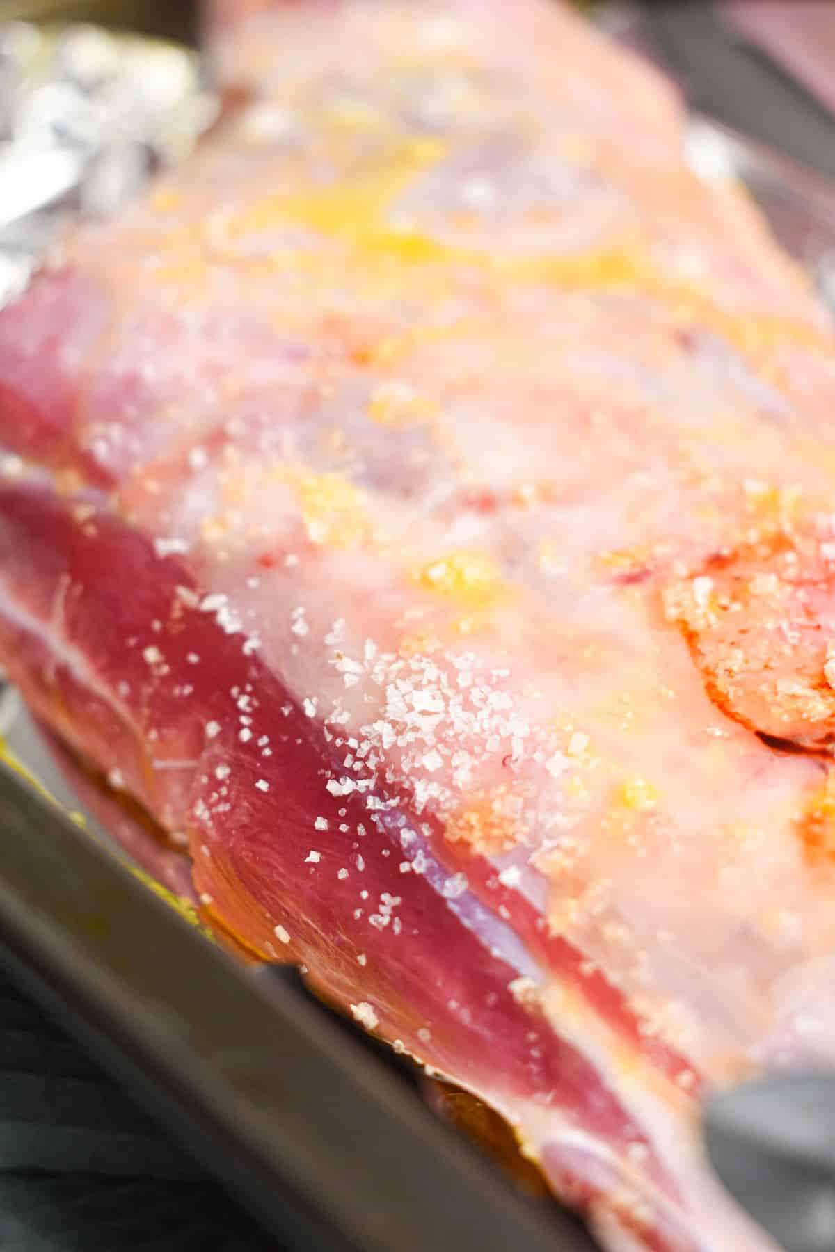 Raw lamb shoulder covered with olive oil and sea salt.