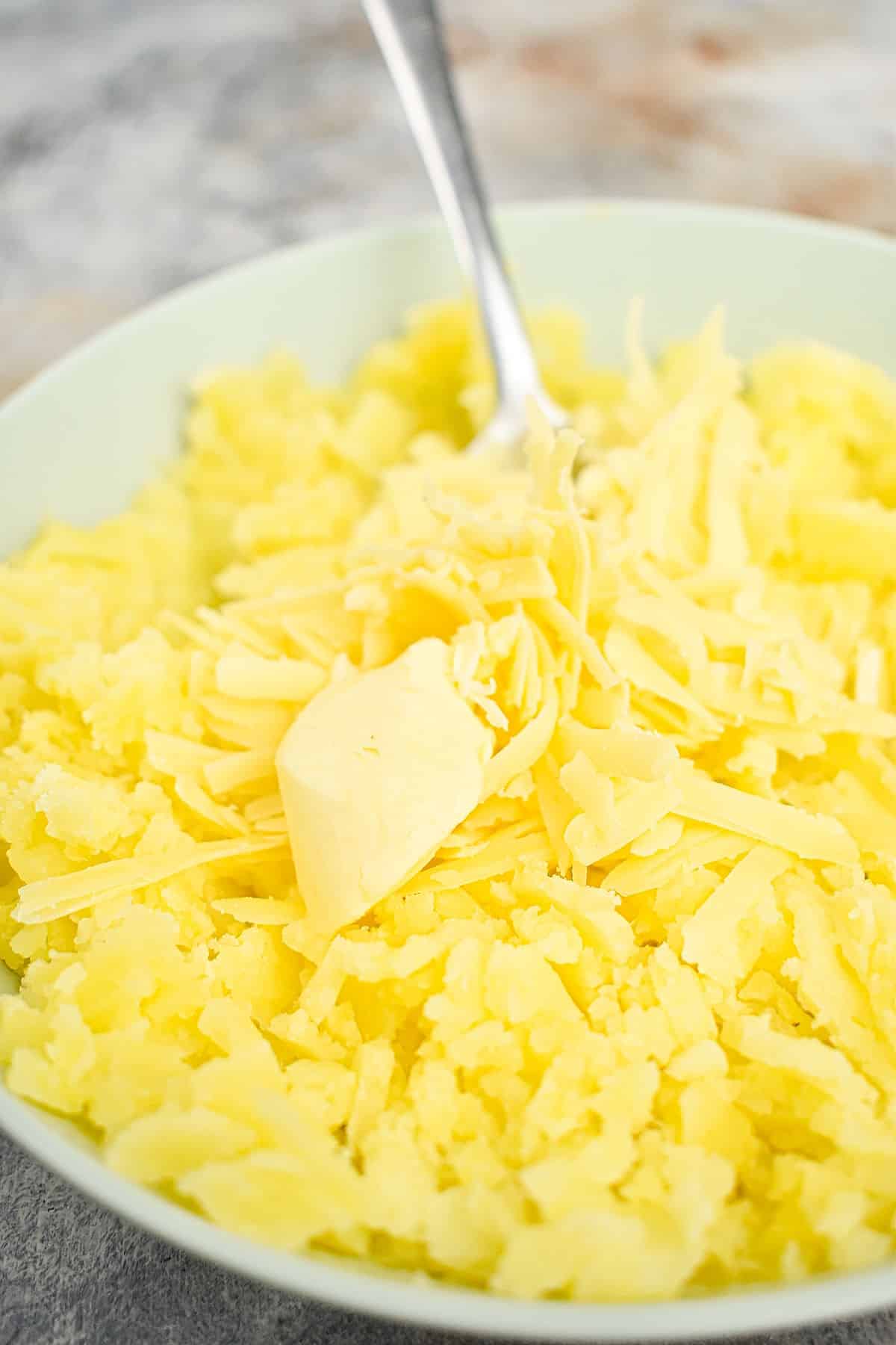 Mashed potatoes with butter and cheese on top.