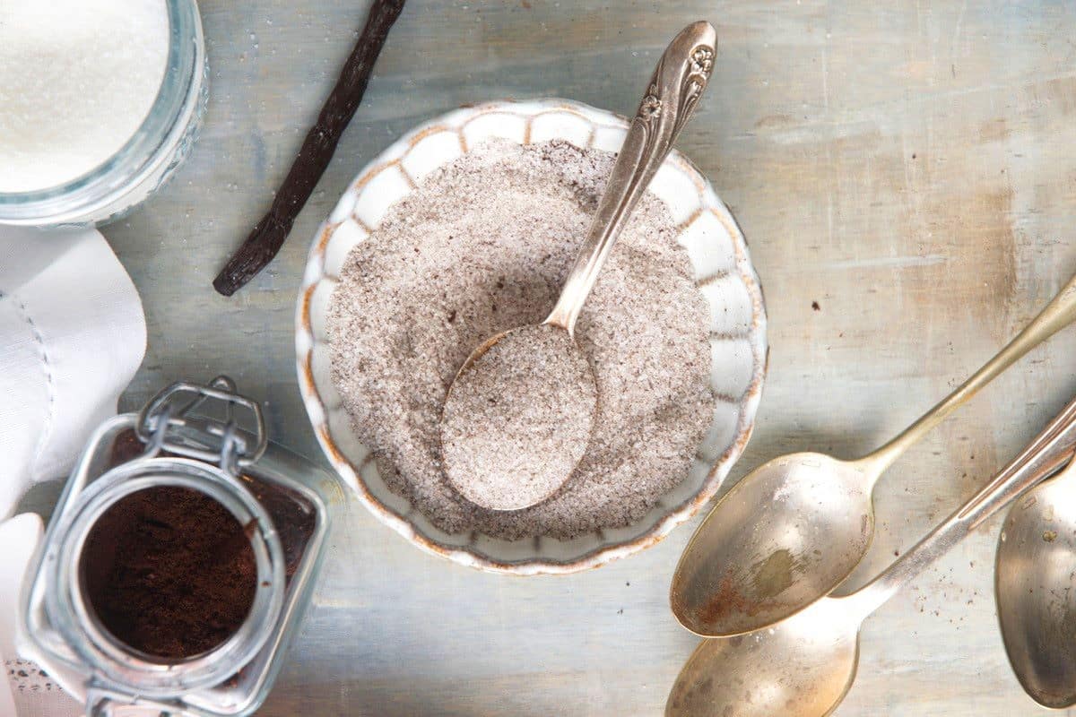 Vanilla powder and sugar mixed together in bowl with spoon.