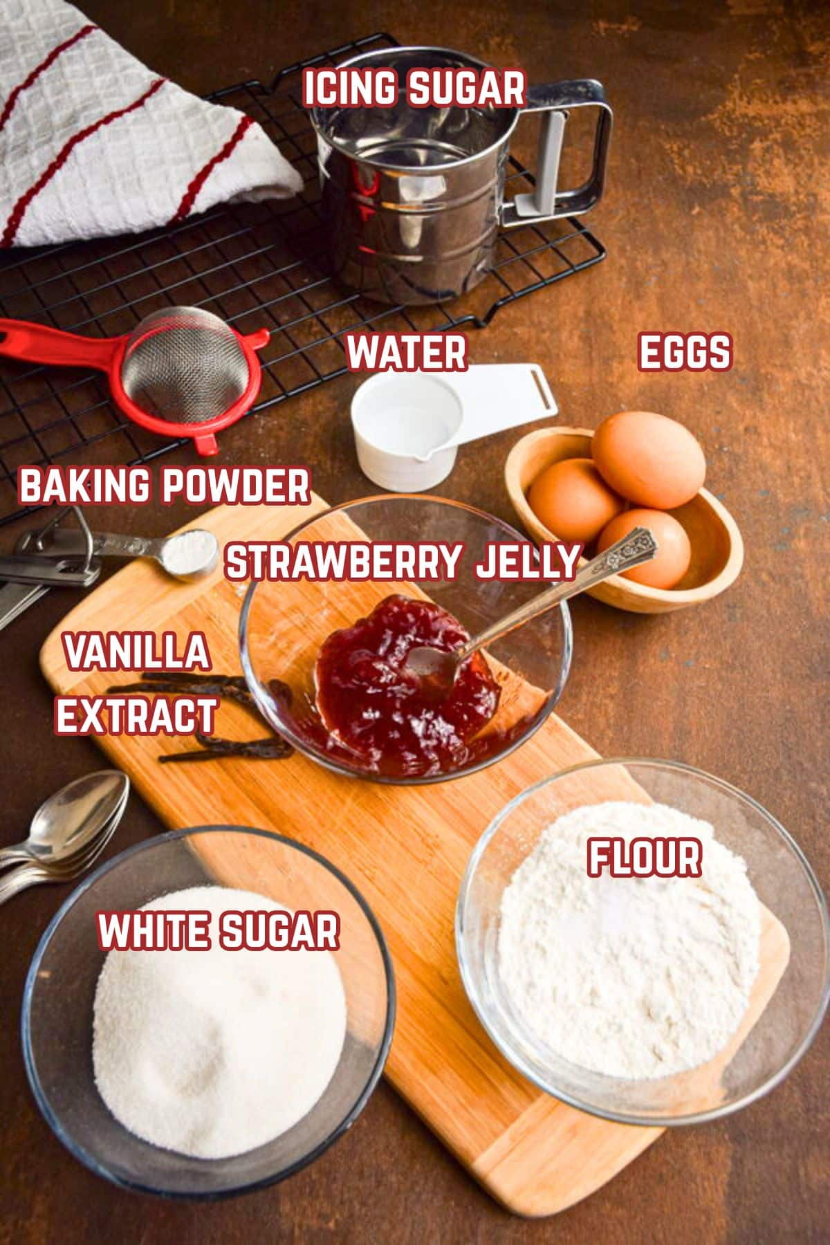 Jelly roll cake ingredients prepped and labeled on wooden board.