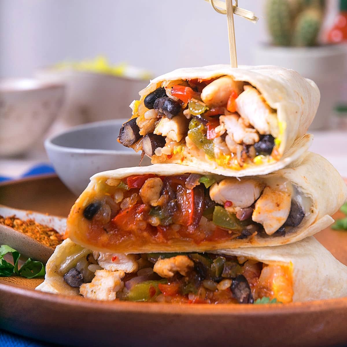 Kimchi burritos cut open and stacked with toothpick.