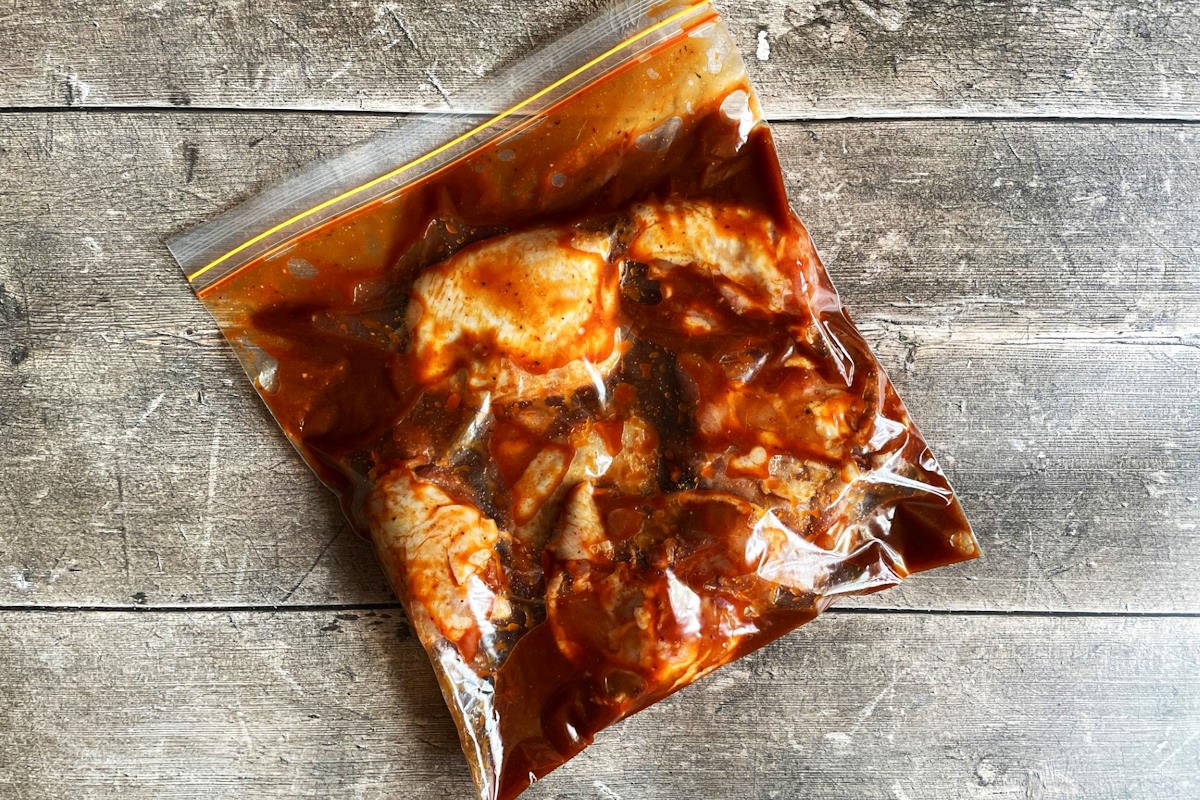 Chicken thighs and kimchi marinade in zip-top bag.