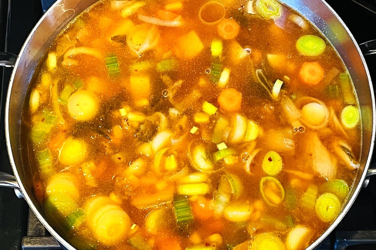 Kimchi, vegetables and broth in pot.