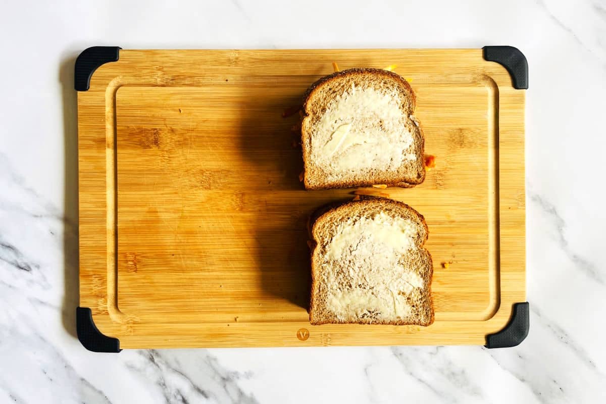 Uncooked kimchi grilled cheese sandwiches with butter on the outside.