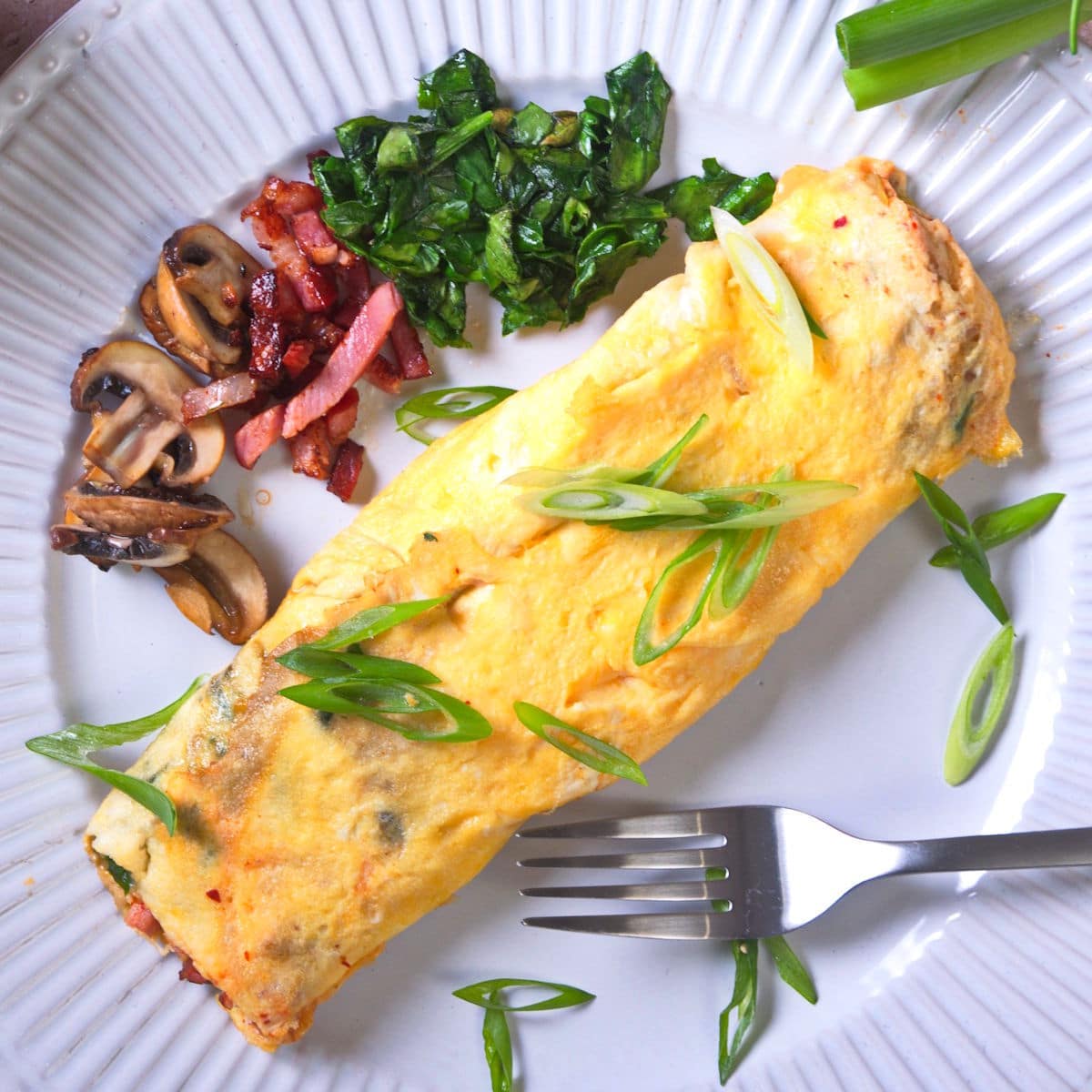 Kimchi omelette on plate with fork.