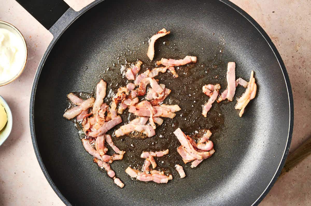 Diced bacon in skillet.