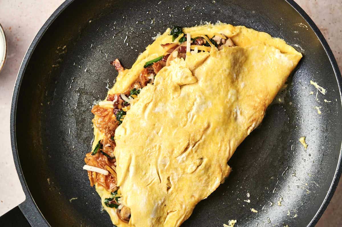 Kimchi omelette folded in pan.
