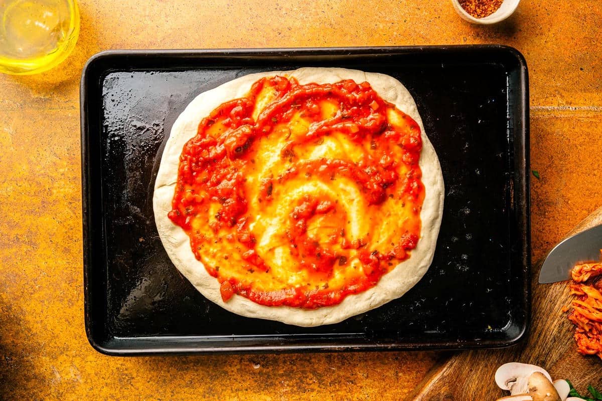 Marinara on pizza dough.