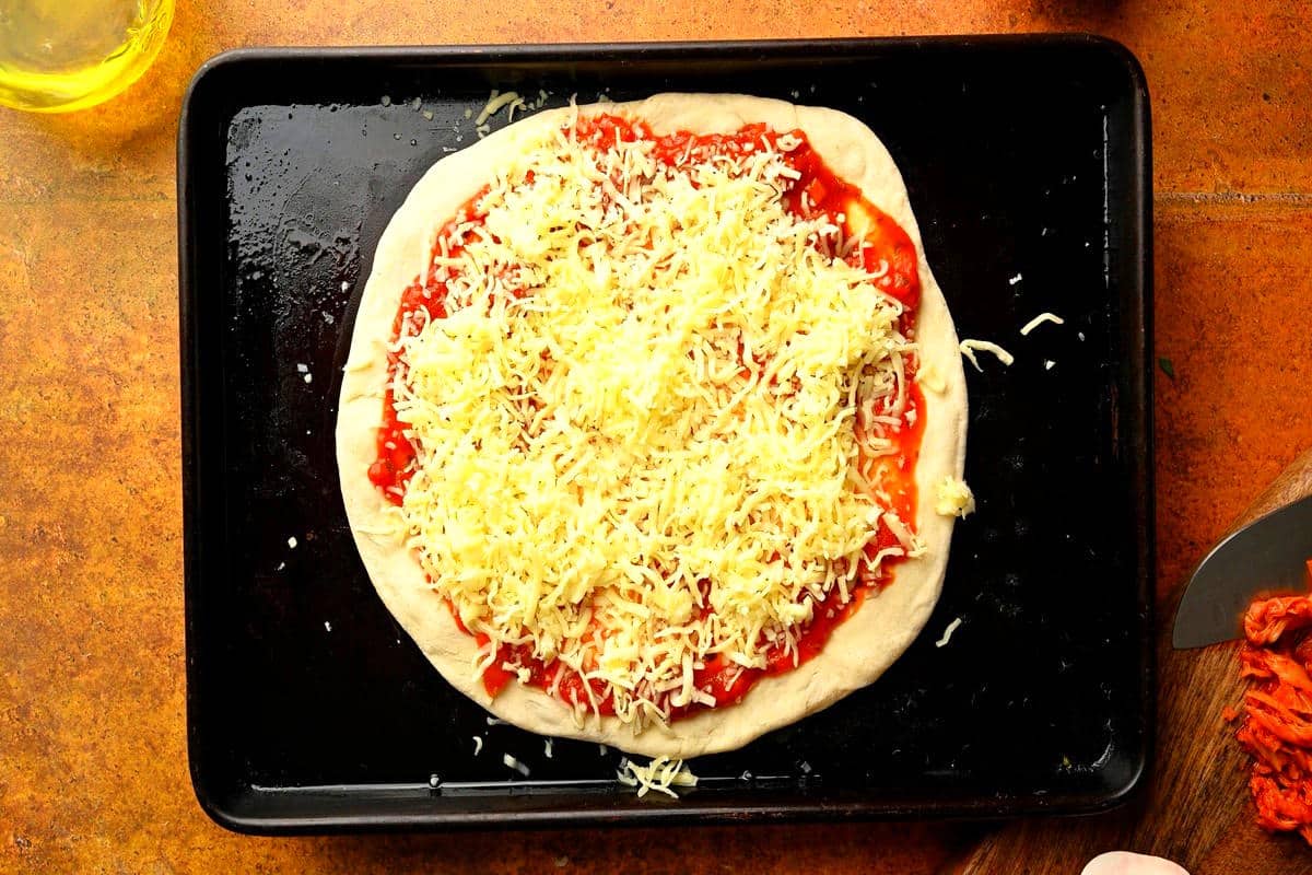 Cheese and marinara on pizza dough.