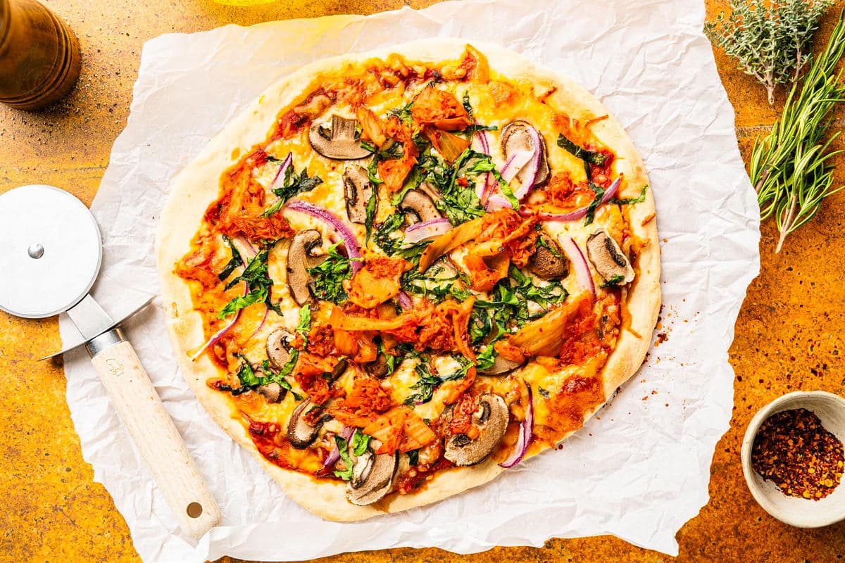 Baked kimchi pizza on parchment.