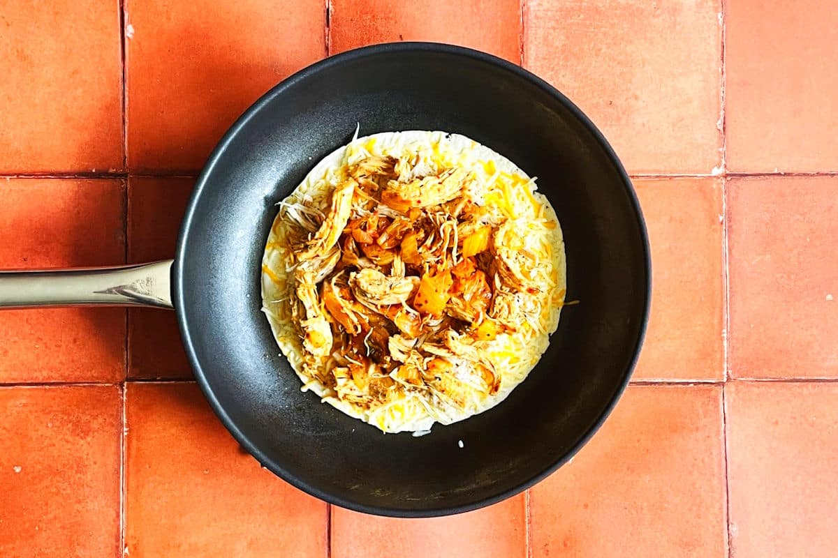 Kimchi quesadilla cooking in pan.