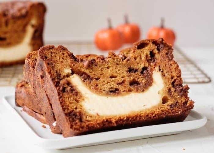 Pumpkin loaf with cream cheese filling on baking rack.