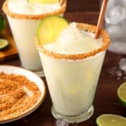 Lime cremosa drink in a glass with straw and lime slice.