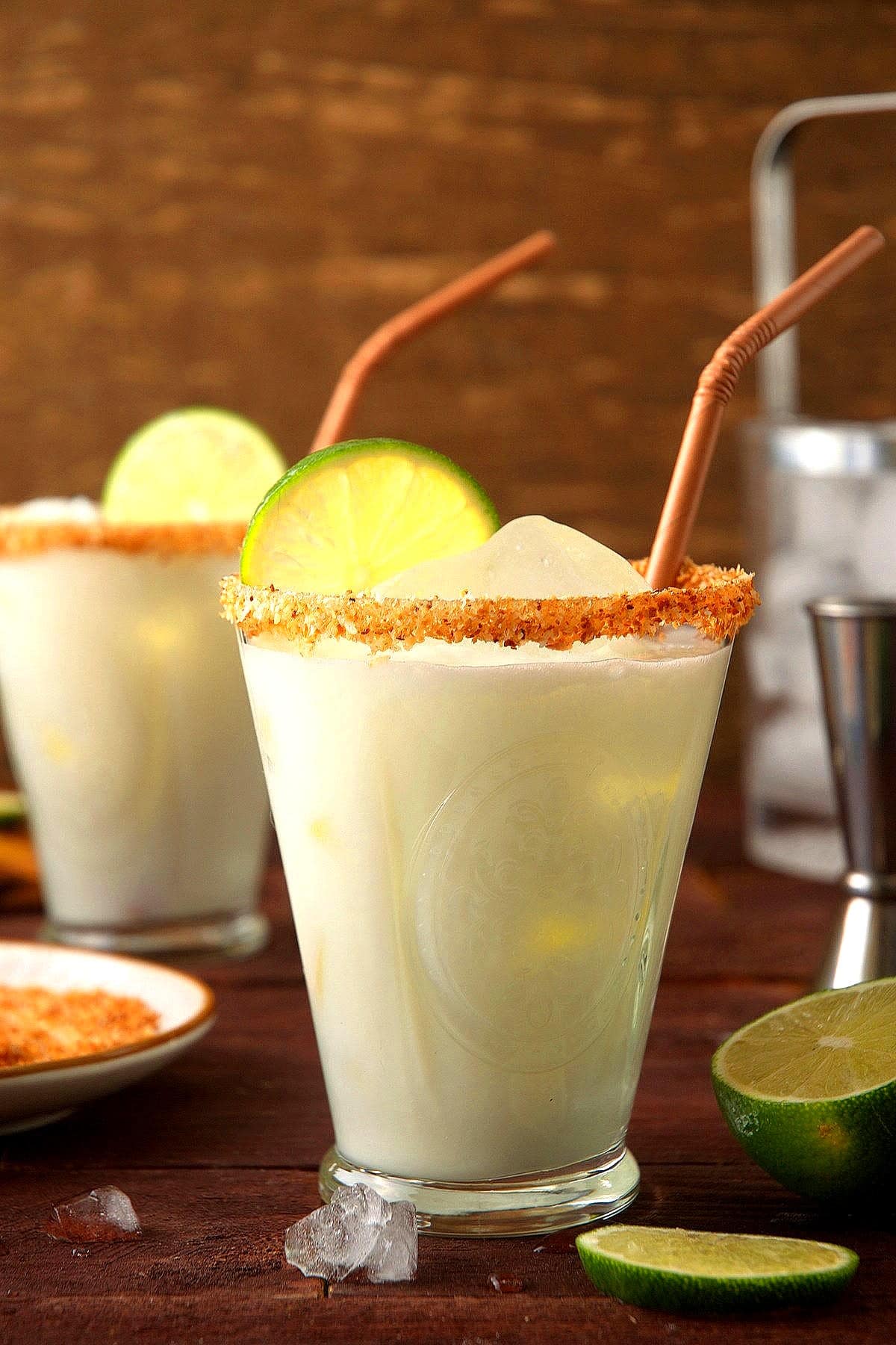 Lime cremosa drink in glasses with brown straws and ice.