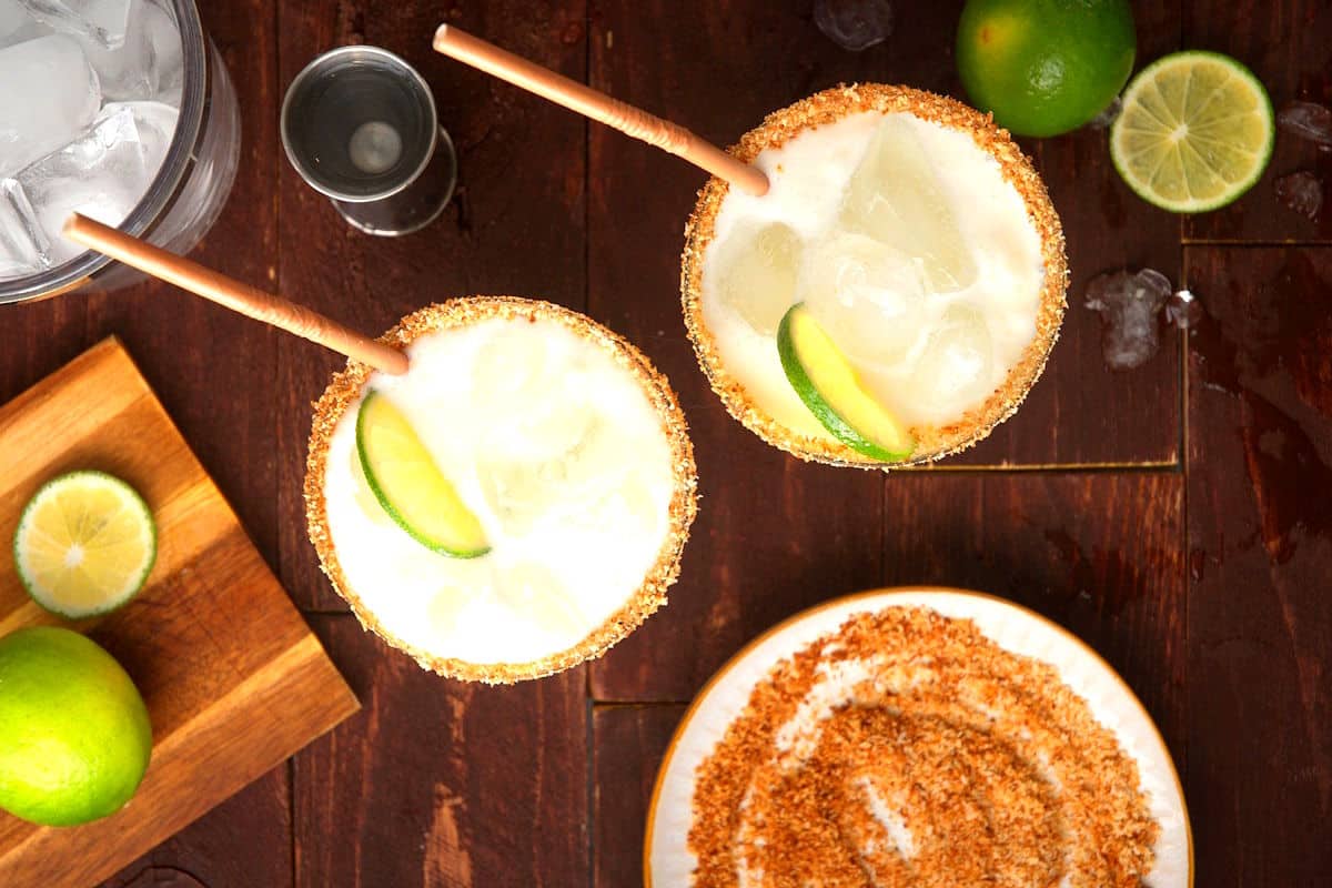 Glasses of lime cremosa with ice, toasted coconut rim and lime slices.