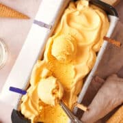 Mac and cheese ice cream in loaf pan with ice cream scoop.