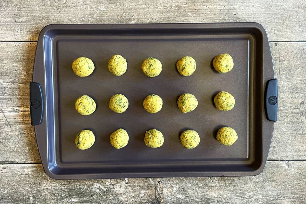 Raw falafel balls on sheet pan.