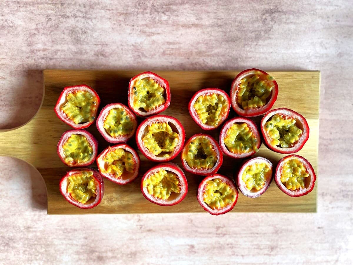 Passion fruits cut open on wooden board.
