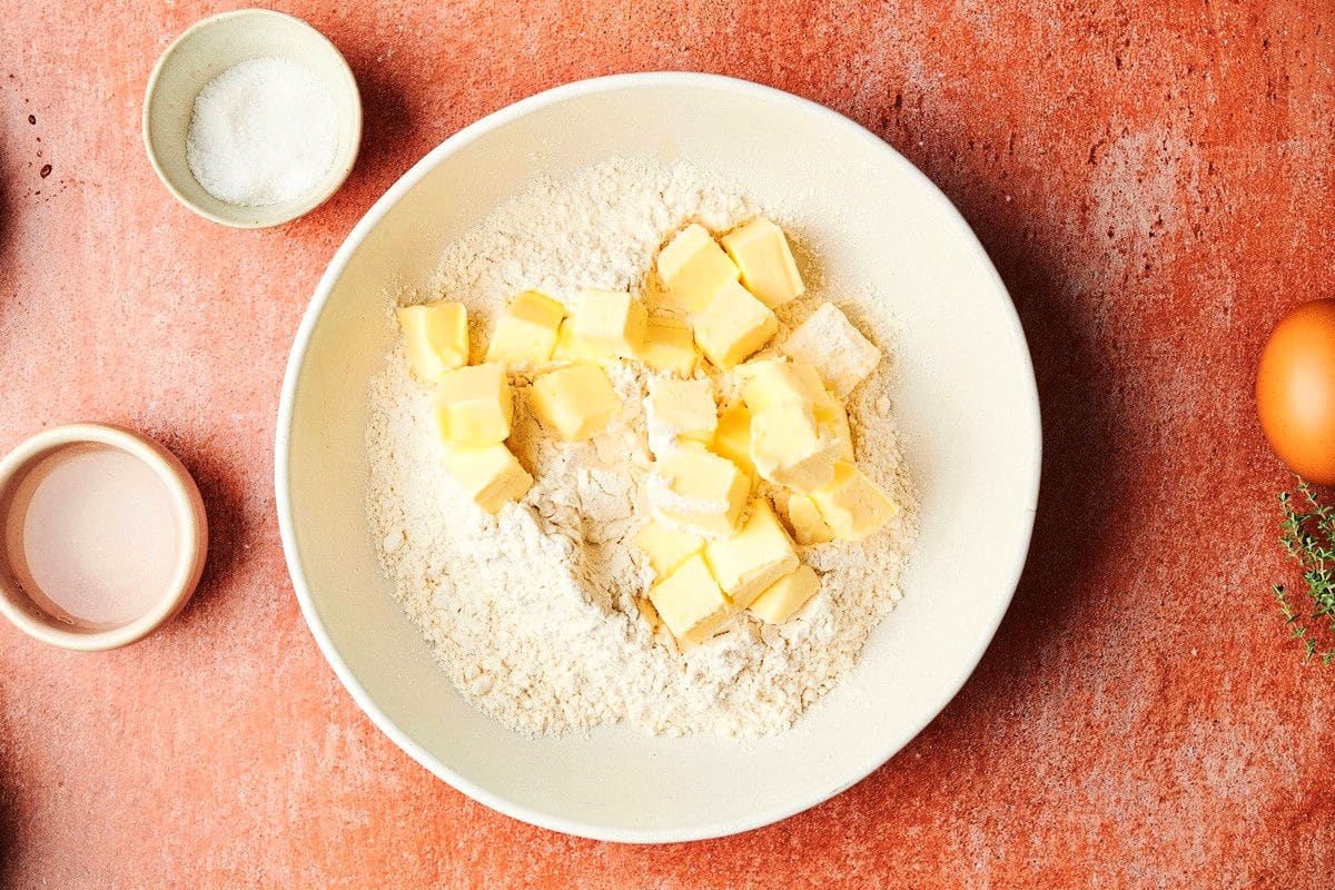 Cubes of butter in bowl of flour.