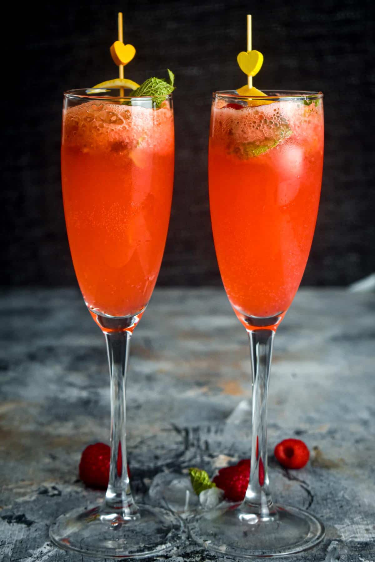 Raspberry twist cocktail in champagne glasses.