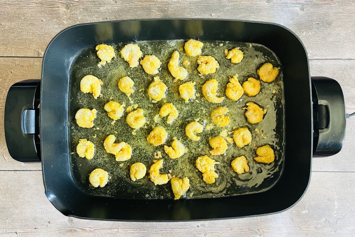 Coconut shrimp frying in skillet.