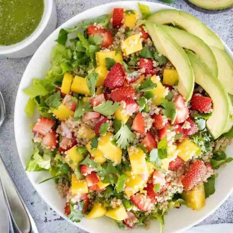 Strawberry mango salad in white dish.