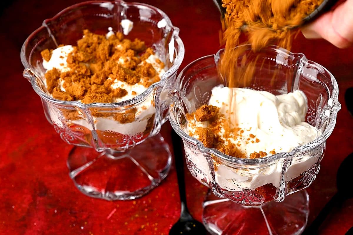 Strawberry parfait getting layered into glass.