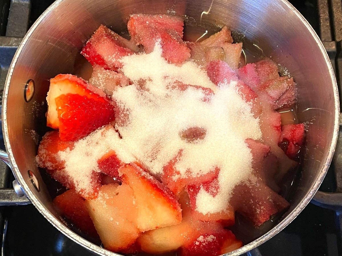 Strawberry rhubarb sauce ingredients in saucepan.