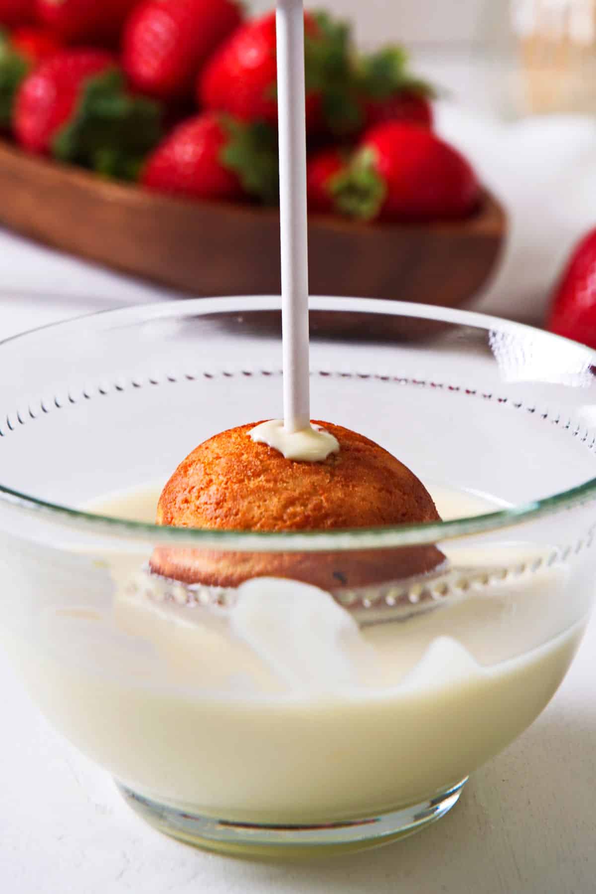 Strawberry shortcake cake pop dipped into white chocolate.