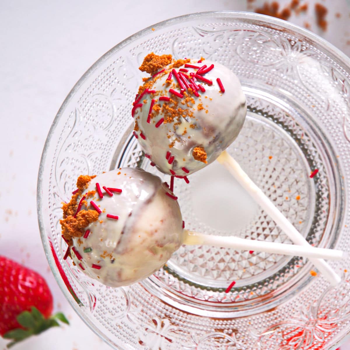 Strawberry shortcake pops with sprinkles and white chocolate coating.