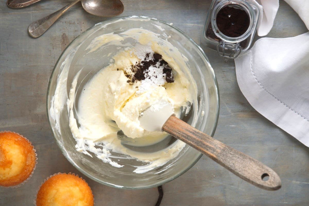 Vanilla powder in bowl of frosting.