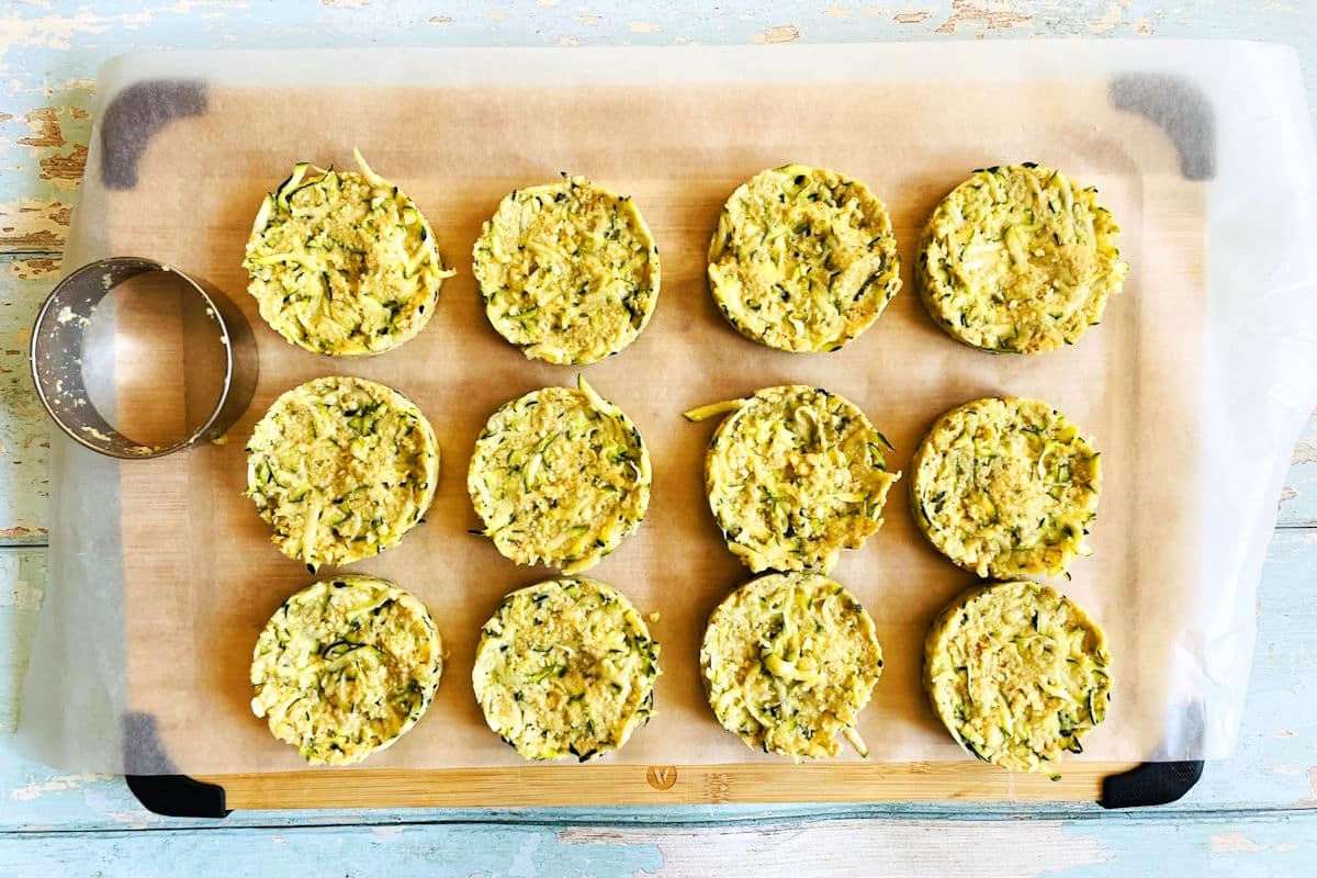 Zucchini crab cake mixture formed into 3" circles on cutting board.